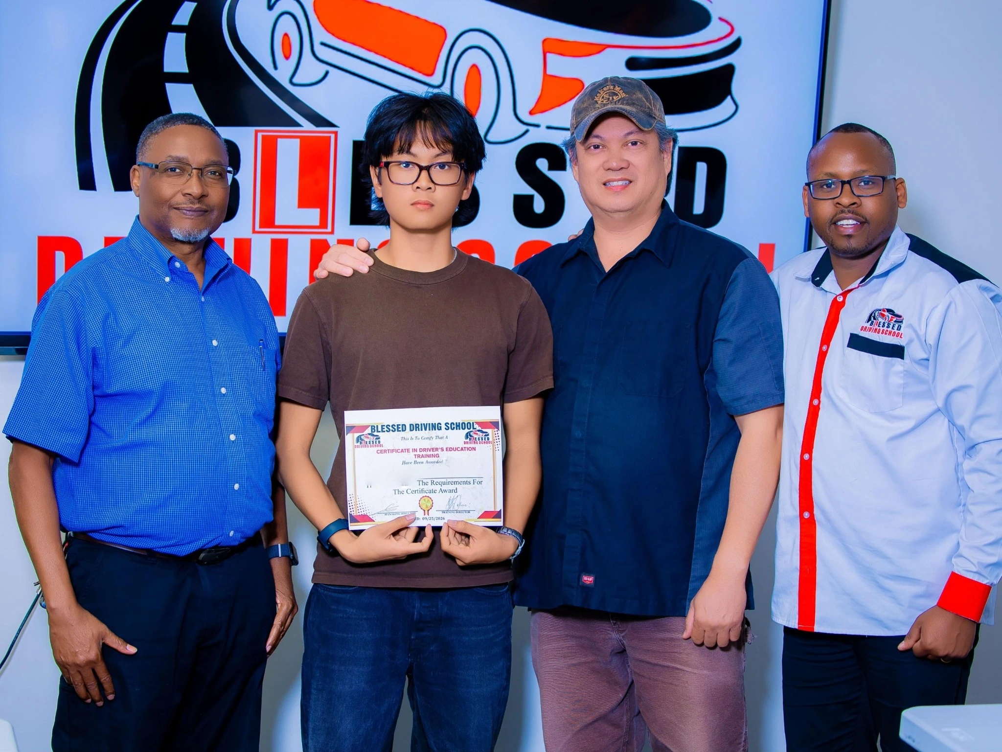 Student receiving a driving education certificate with the Blessed Driving School team