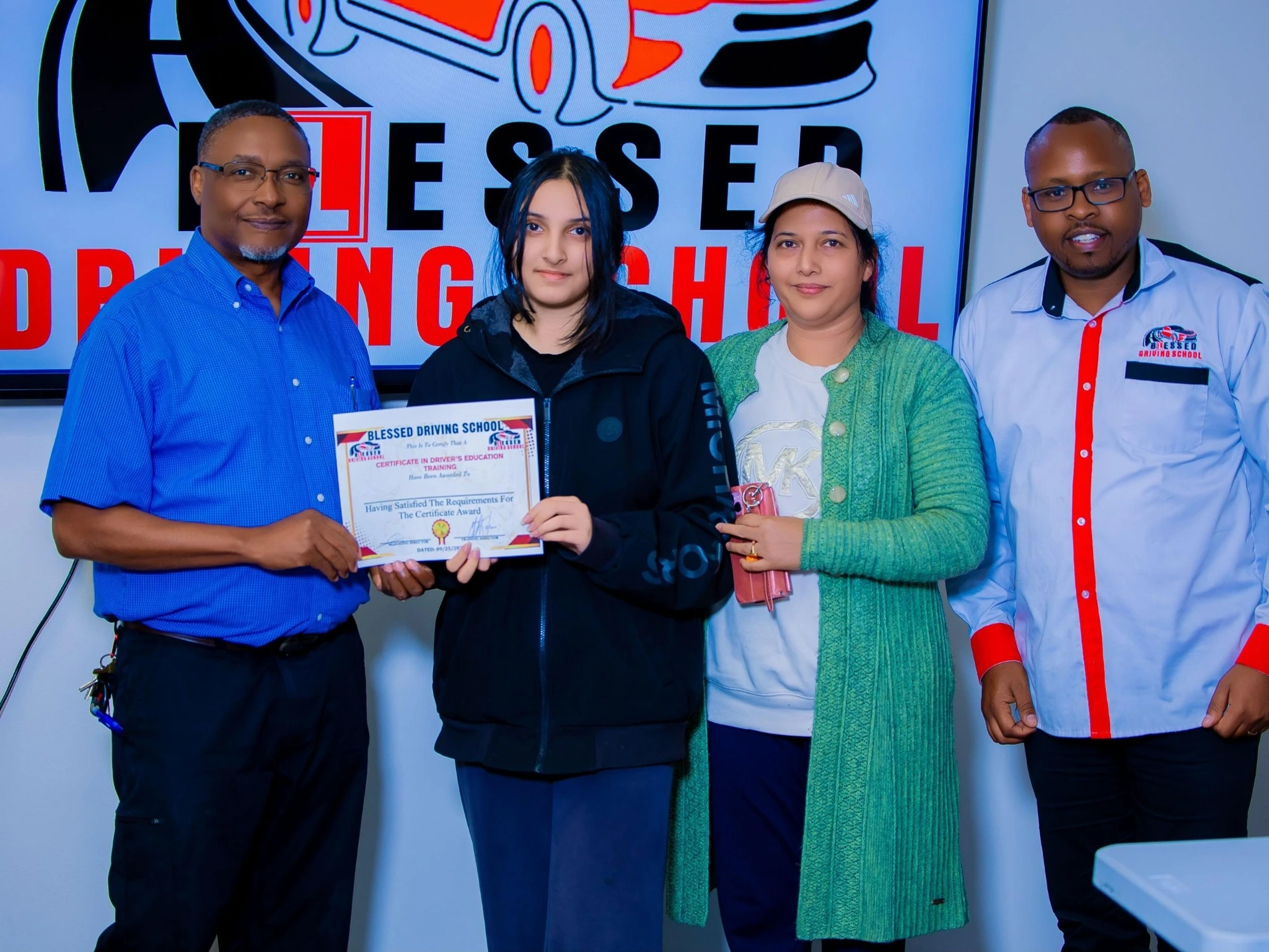 Student and family celebrating a driving education certificate with the school team